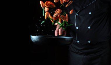 Profesyonel aşçı ya da aşçı bitkilerle karides hazırlar. Deniz ürünleri pişirmek, sağlıklı vejetaryen yemekleri ve siyah arka planda yiyecekler. Ücretsiz reklam alanı