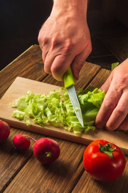 Restoranın mutfağında salata pişirmek. Şef, eller yakın plan salata salatası. Salata diyeti için sebze..