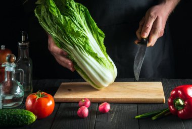 Profesyonel şef ya da aşçı taze lahana salatası yapar. Restoranın mutfağında dilimleme hazırlığı. Sebze diyeti fikri.