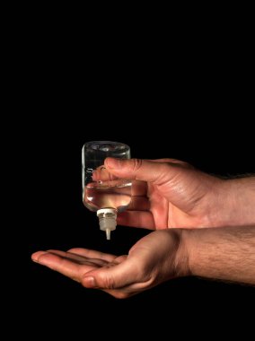 İnsan elleri jel, dezenfektan, baloncukta antiseptik, siyah arka planda kavanoz kullanır. Hastalıkların ve enfeksiyonların önlenmesi. Ücretsiz reklam alanı