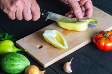 Şefin elleri taze dolmalık biber keser. Restoranın mutfağında salata pişirmek. Salata diyeti için sebze..