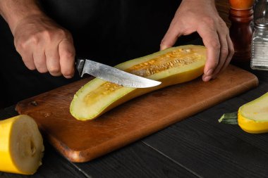 Aşçı olgun sarı iliği bir bıçakla keser. Kızarmış kabak kahvaltı ya da öğle yemeği için harika bir diyettir. Restoranın mutfak masasında çalışma ortamı.