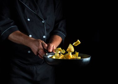 Profesyonel şef kabağı tavada pişirir. Sebze pişirmek sağlıklı vejetaryen yemeği ve yemeği karanlık bir arka planda pişirmek. Ücretsiz reklam alanı.