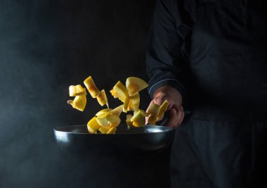 Aşçı kabağı tavada hazırlar. Sebze pişirmek sağlıklı vejetaryen yemeği ve yemeği karanlık bir arka planda pişirmek. Ücretsiz reklam alanı.