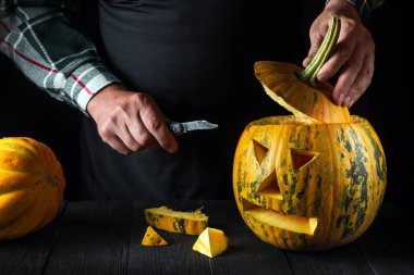 Aile eğlencesi aktivitesi. Cadılar bayramı için balkabağı oyulmuş balkabağı. Bıçak tutan adam..