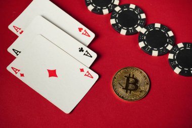 Three aces and black and white poker chips are laid out on a vibrant red background next to a shiny Bitcoin coin, highlighting a modern gaming scene.