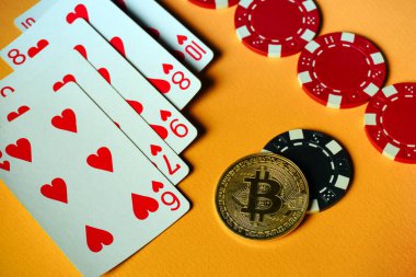 Kalp rengi şeması ile tasvir edilen düz floş kartlar, kırmızı ve siyah poker fişleri ve bir Bitcoin para ile serilmiştir. Oyunun heyecanını ve kripto para birimini aktarıyor..
