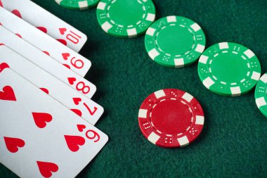 Yeşil bir keçeli masaya saçılmış poker fişleri olan bir kart oyunu. Kartlar, floşun galibiyet kombinasyonunu gösteriyor. Dostça bir rekabet ortamı yaratıyor..