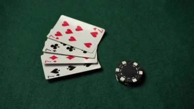 Yedileri gösteren dört iskambil kartı ve bir oyuncunun eli bahis oynayarak oyun akşamı için rahat bir ortam yaratıyor..