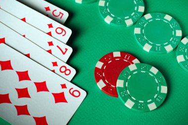 Bir deste iskambil kağıdı, floşu gösteriyor, yeşil bir masanın üzerinde kırmızı ve yeşil kumarhane fişlerinin yanında duruyor. Bu sahne arkadaşlarla sıradan bir oyun gecesinin heyecanını yakalıyor..