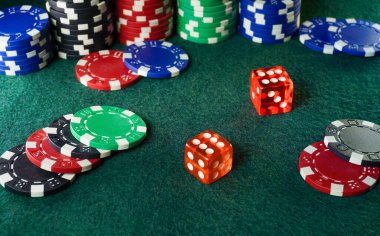Değişik renklerde çeşitli poker çiplerinin canlı bir düzeni yeşil keçeli masa üzerindeki iki kırmızı zarın etrafını sarar. Ayarlar, heyecan dolu bir oyun gecesi atmosferini akla getiriyor..