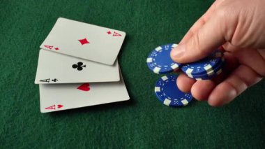 Bir el, mavi poker fişleri ya da bahisleri yeşil bir masaya serilmiş üç el ya da bir set üzerine koyar. Kartlar üç as gösteriyor.