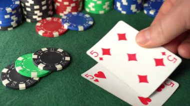 Bir oyuncunun eli poker masasına dört beşlik ya da dörtlü bir kombinasyon yerleştirir. Etrafta bir sürü para var..