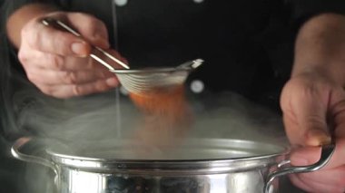 Bir oyuncunun eli üç yedili gösterir. Kartın etrafına birkaç kırmızı ve siyah poker fişi yerleştirildi. Aksiyon karanlık bir masada gerçekleşiyor..