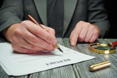 Bir el bir kalemi tutar ve rapor etiketli bir kağıt parçasına yazar. Bir büyüteç ve bir altın eşya masa yüzeyinde oturup, elimizdeki göreve odaklanmamızı sağlıyor..