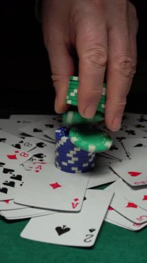 Poker çiplerini bir destenin üstüne koyup yeşil bir keçeli masaya dağıtmak, her çerçevedeki çiplerin düzenini ve ilerleyişini vurgulamak.