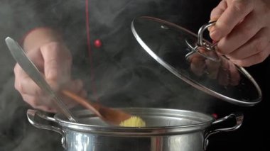 Siyah üniformalı şef, tek eliyle paslanmaz çelik tavanın kapağını kaldırıyor. Mutfak masasında tahta kaşıkla paniğe kapılıyor..