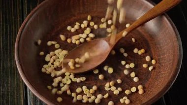 Bezelyeler, lapa yapmadan önce tahta kaşıkla eski moda bir kaseye doldurulur. Akşam yemeği için baklagiller hazırlanıyor..