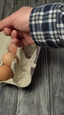 El yumurtaları katlamak için kutuyu açar. Kahvaltı için yumurta yemeği hazırlama süreci.