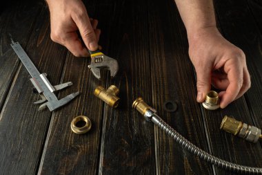 Atölyedeki tezgahta çalışan profesyonel tesisatçı. Gaz teçhizatının onarılması veya pirinç tesisatlarının bağlanması.