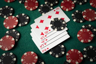 Bir sürü fiş arasında yeşil bir masada floş kombinasyonuyla kağıt oynamak. Birileri pokerde kazanma konusunda şanslı olabilir..