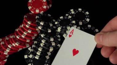 El masaya kırmızı ve siyah poker çiplerinin yanına iki as koyar, oyunun atmosferini ve bir çiftin kartlarının önemini vurgular..