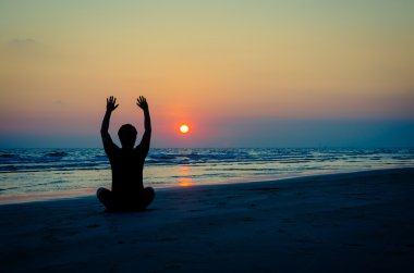 sunset Beach Yoga egzersiz yaparak insan silueti