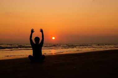 sunset Beach Yoga egzersiz yaparak insan silueti