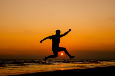 mutlu bir adam bir gün batımı atlama silüeti