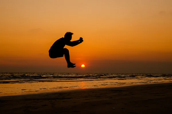 Silhouette of a happy man jumping on a sunset — Stock Photo, Image
