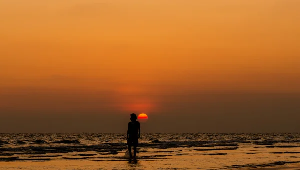 Silueta muže, chůze na západ slunce na pláži — Stock fotografie