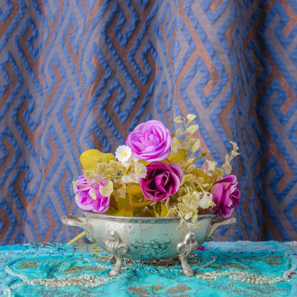Tigela de metal marroquino colocado em uma mesa com flores . — Fotografia de Stock