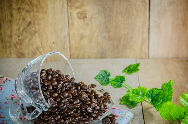 Granos de café con taza en la mesa de madera — Foto de Stock