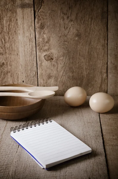 Libro di cucina aperto e utensili da cucina su sfondo di legno — Foto Stock