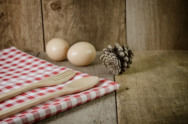 Tovaglia, cucchiaio di legno, forchetta su sfondo con texture in legno — Foto Stock