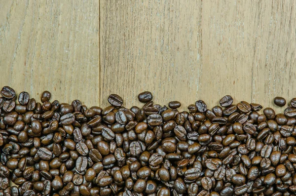 Geröstete Kaffeebohnen auf Holz Hintergrund — Stockfoto