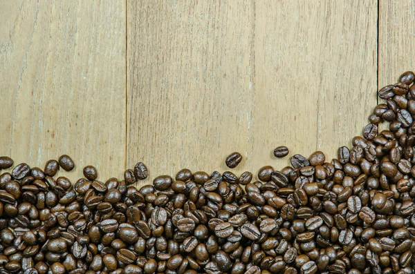 Geröstete Kaffeebohnen auf Holz Hintergrund — Stockfoto