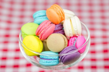 Damalı masa örtüsü üzerinde renkli macaroons