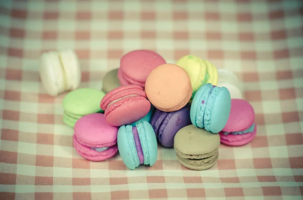 Colorful macaroons on checkered tablecloth — Stock Photo, Image