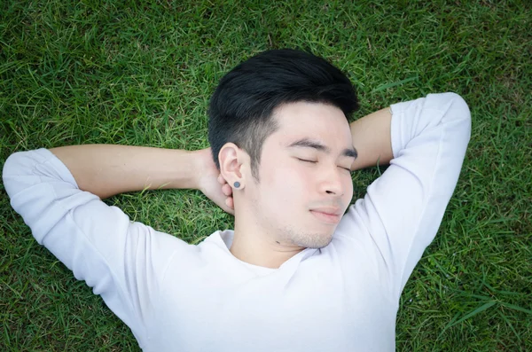 一个年轻人快乐放松他汉与草地上的肖像 — 图库照片