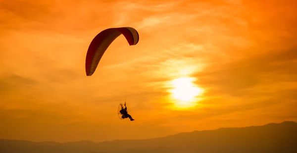 在夕阳的剪影滑翔伞 — 图库照片