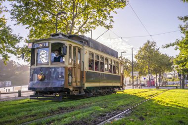 Porto, Portekiz - 12 Ağustos 2020: Portekiz gün batımına kadar Porto şehir merkezine giden klasik tramvay şebekesi maskeli sürücü
