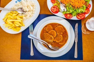 Traditional food from Alentejo - cow's tongue in a sauce served with salad, rice and french fries, Portugal, Europe