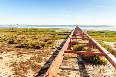 Ria Formosa Doğal Parkı, Olhao, Algarve, Portekiz 'de terk edilmiş bir iskelesi olan güzel bir manzara.