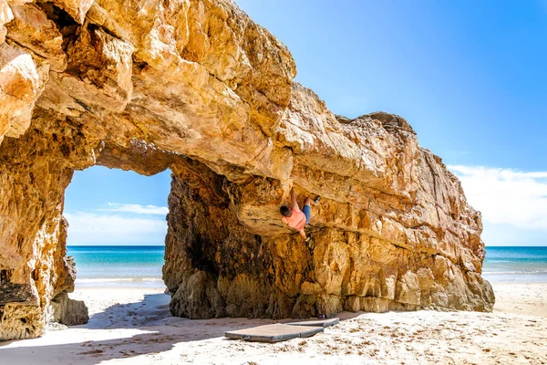 若いロッククライマーはポルトガルのアルガルヴェにある黄色の崖を安全に登る — ストック写真