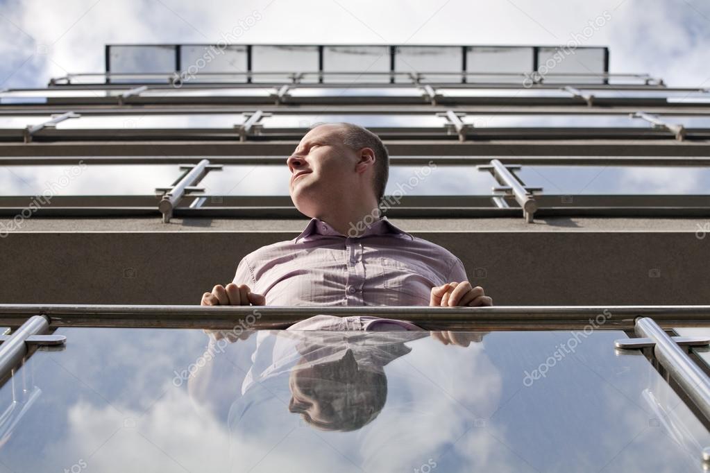 Man looking toward the sun from modern apartment