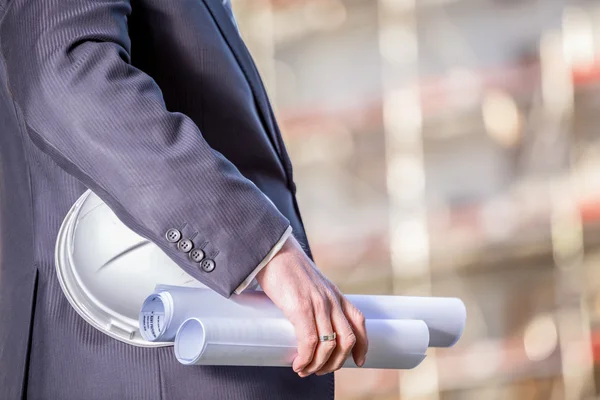 White helmet and blueprints on construction site — Stock Photo, Image