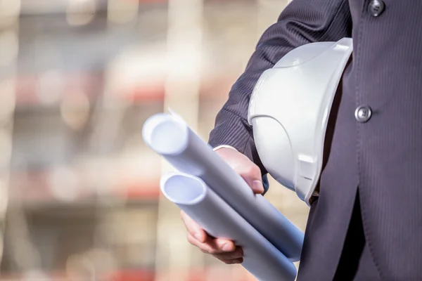 White helmet and blueprints on construction site — Stock Photo, Image