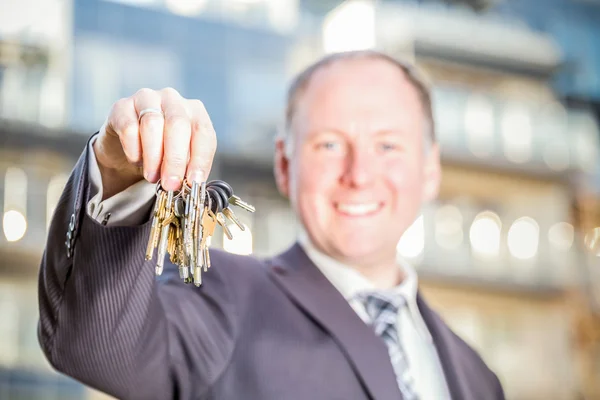 Man encouraging to choose key to brand new apartments — Stock Photo, Image