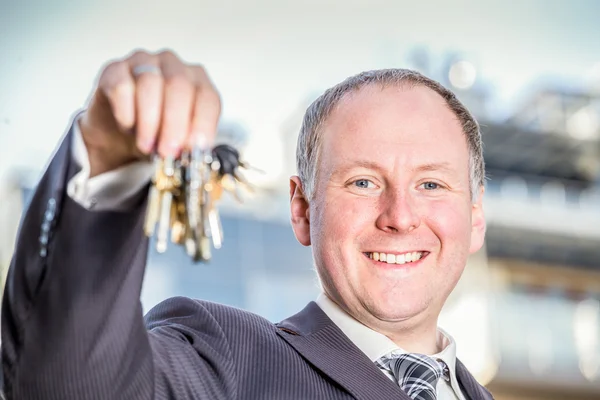 Homme encourageant à choisir la clé des appartements flambant neufs — Photo